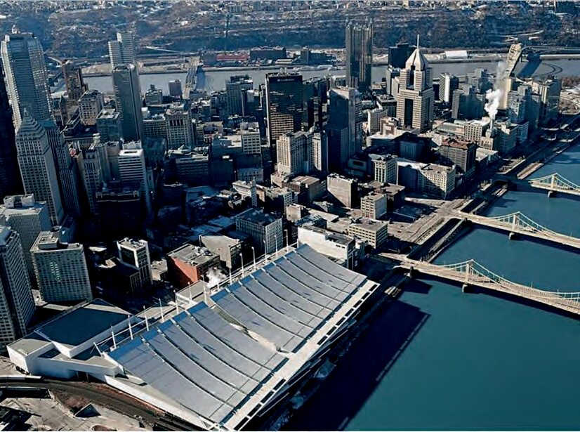 Aerial view of the convention center's curved roof beside the river and downtown Pittsburgh — the worksite Volpatt's crew was replacing.